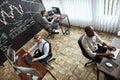 Doing our best. High-angle view of three traders sitting by desks in front of computer monitors while working in the