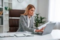 Doing paperwork. Woman in business formal clothes is working in office Royalty Free Stock Photo