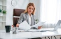 Doing paperwork. Woman in business formal clothes is working in office Royalty Free Stock Photo