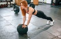 Doing push ups by using soft ball. Beautiful strong woman is in the gym Royalty Free Stock Photo