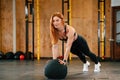 Doing push ups by using soft ball. Beautiful strong woman is in the gym Royalty Free Stock Photo