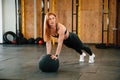 Doing push ups by using soft ball. Beautiful strong woman is in the gym Royalty Free Stock Photo