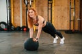 Doing push ups by using soft ball. Beautiful strong woman is in the gym Royalty Free Stock Photo