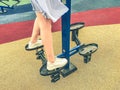 Doing sports on the simulator in the park in the fresh air. a girl in a blue dress trains her legs on the platform. athlete in Royalty Free Stock Photo