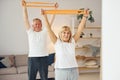 Doing stretching and fitness exercises. Senior man and woman is together at home Royalty Free Stock Photo