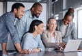 Doing a trial run of her presentation. a diverse group of businesspeople gathered around a laptop during a meeting in