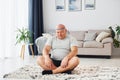 Doing yoga exercises. Funny overweight man in casual clothes is indoors at home Royalty Free Stock Photo