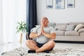 Doing yoga exercises. Funny overweight man in casual clothes is indoors at home Royalty Free Stock Photo