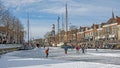 Skaters on the frozen river Ee in historical Dokkum in the Netherlands in winter