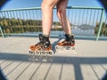 Roller skater ride in park. Boy legs in in-line hard shell boots blades.