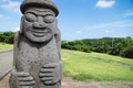 Dol Harubang statue in green grassland at Yongmeori Beach, Sanbang-ro, Jeju Island, South Korea