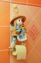 Doll as clamp holder of toilet paper