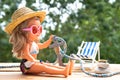 Doll in bathing suit, summer straw hat, sunglasses, sea anchor, starfish on old wooden table, anticipation summer adventures, Royalty Free Stock Photo