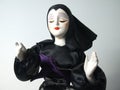 Doll in black habit giving blessing