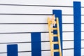 Doll character on ladder near blue graphs at background