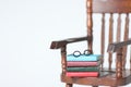 Doll house interior - a pile of books and glasses on the armchair isolated against white background Royalty Free Stock Photo