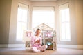 Doll house, portrait and girl child in home playing with toys for growth, development and fun. Smile, sweet and young Royalty Free Stock Photo