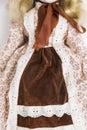 Doll in old textile brown dress with floral print