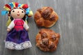 Colorful handmade cloth doll with pan de muerto from the town with sesame in the offering for the Day of the All Souls and All Sai