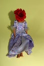 the doll's body in a beautiful blue-purple dress has a red flower instead of a head