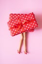 Doll& x27;s legs under gift boxes. Christmas or Valentine& x27;s day shopping concept Royalty Free Stock Photo