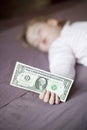 Dollar banknote in hand of baby sleeping Royalty Free Stock Photo