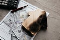 A dollar banknotes and a burn house on an insurance contract. Destruction of a home and insurance services Royalty Free Stock Photo