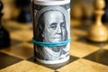 Dollar banknotes roll with Franklin on chessboard, US cash and chess