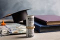 Dollar banknotes and student graduation hat on table. Tuition fees concept Royalty Free Stock Photo