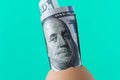 100 dollar bill in an egg shell. On a turquoise background. The Royalty Free Stock Photo