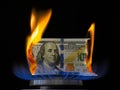 Dollar bill on fire in gas burner flame.