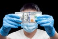 100 dollar bill in hands in medical gloves holds a man in a sick mask.