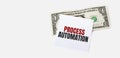 1 dollar bill and white notepad sheet on the white background. PROCESS AUTOMATION text Royalty Free Stock Photo