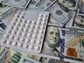 Dollar bills among blisters with white pills world conspiracy