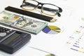 Dollar bills, calculator, pen, glasses, business charts are all on the table. Royalty Free Stock Photo