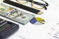 Dollar bills, calculator, pen, glasses, business charts are all on the table. Royalty Free Stock Photo