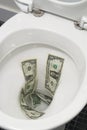 US one dollar bills flushed down the toilet, toilet paper worthless money concept Royalty Free Stock Photo