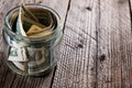 Dollar bills in glass jar on wooden background. Saving money concept Royalty Free Stock Photo