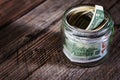 Dollar bills in glass jar on wooden background. Saving money concept Royalty Free Stock Photo