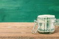 Dollar bills in glass jar on wooden table. Royalty Free Stock Photo