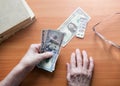 Dollar bills in the hands of a pensioner