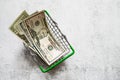 Dollar bills in a metal mini grocery shopping basket on a light background. Conceptual image of sh