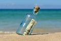 10 dollar in a bottle on the beach Royalty Free Stock Photo