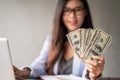 Dollar in a businesswoman hand. A Asia woman is working from home or office and glad to get dollar money from work and from a Royalty Free Stock Photo