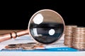 Dollar coin and magnifying glass on financial documents Royalty Free Stock Photo