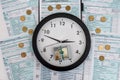 Dollar coins and banknotes with clock at 1040 form