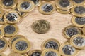 1 dollar coins in the middle of several 1 real coins on a wooden