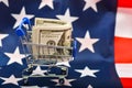 Dollar in a consumer basket on the background of the American flag, the concept of world domination and global government Royalty Free Stock Photo