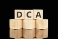 Dollar cost averaging DCA text on wooden cubes on a black background