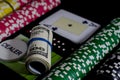 A 100 dollar kupurs is on the blackjack table next to poker chips and a dealer's chip Royalty Free Stock Photo